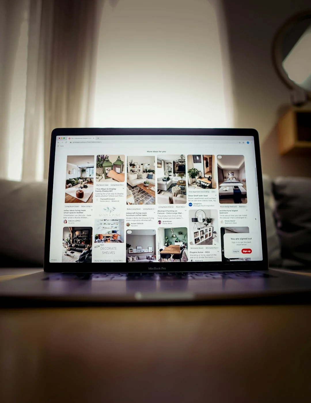 Un homme retouche l’image d’un fruit sur un MacBook Pro en étant assis dehors sur l’herbe.